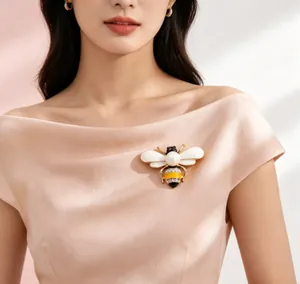 Close-up of an elegant bee brooch with pearl and rhinestones on a silk dress