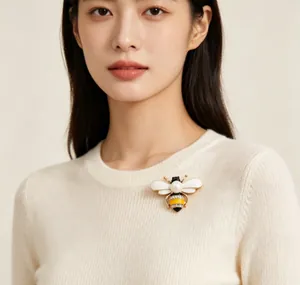 Detail shot of a cute bee brooch with pearl and yellow enamel pinned on a sweater