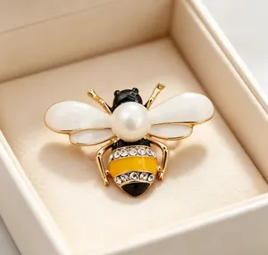 Detailed macro shot of an elegant bee brooch featuring a central pearl and rhinestones