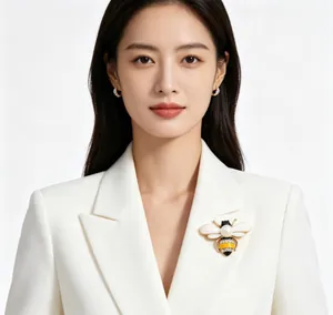 Detailed view of an elegant honeybee brooch with pearl and rhinestones worn on a white blazer