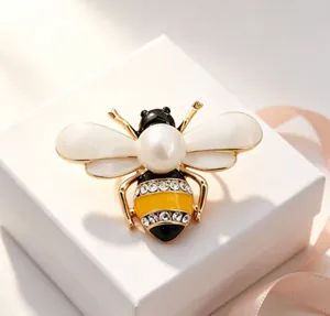 Detailed macro view of an elegant insect bee brooch featuring a large pearl and rhinestones