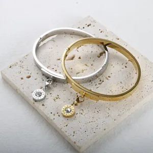 Elegant 18K gold and silver plated bangles featuring Roman numeral charms with crystals.