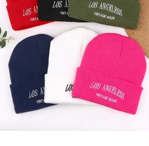 Detail view of various colored knitted beanies featuring Los Angeles vintage embroidery