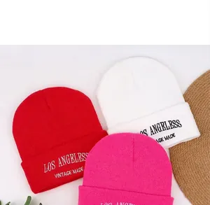 Detail of knit beanies in red white and pink with Los Angeles embroidery