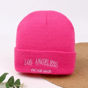 Vibrant hot pink knitted beanie hat featuring white Los Angeles embroidery detail.