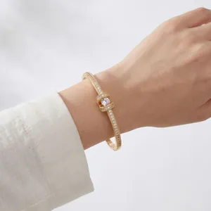 Elegante bracciale rigido a nodo placcato oro con zirconi scintillanti da donna.