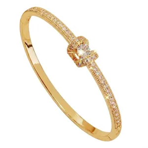 Elegante bracciale rigido dorato con pavé di zirconi e chiusura a scatto sicura