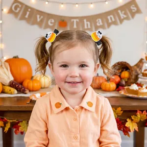 Detail view of cute candy corn embroidered safety hair clips worn by a toddler girl