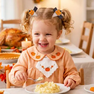 Close-up of a young girl wearing cute pumpkin embroidered hair clips during Thanksgiving feast