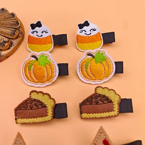 Detailed embroidery of Thanksgiving pumpkin and candy corn hair clips for girls.