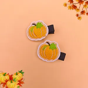 Two adorable embroidered pumpkin hair clips for children Thanksgiving celebration