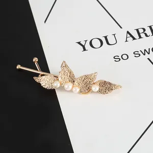 Detailed view of an elegant golden leaf hair clip featuring delicate pearl accents