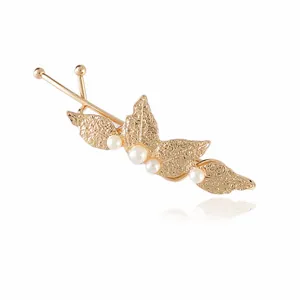 Detailed macro view of golden leaf hair clip with elegant white pearl accents for women