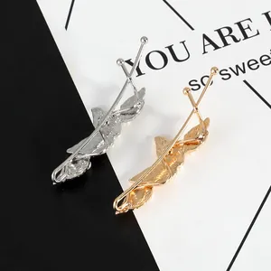 Detailed back view of gold and silver leaf-shaped hair clips with pearl design