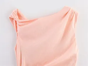 Close-up detail of peach asymmetrical neckline midi dress with linen texture