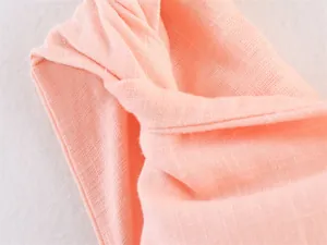 Detailed macro close-up showing the pink linen-blend fabric texture of a midi dress