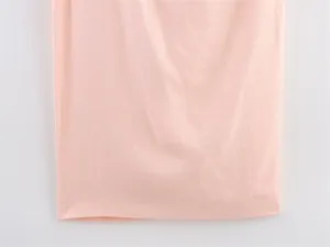 Close-up view of the soft pink linen-texture fabric and hem detail for asymmetric dress