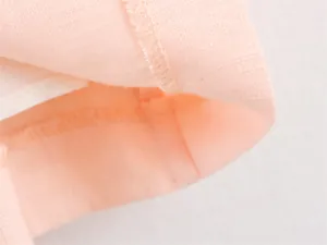 Close-up of pink midi dress fabrics showing texture and neat stitching details.
