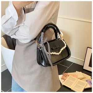 Detailed view of a black Korean style handbag featuring a cute bow and lace trim decoration
