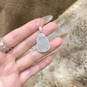 Detailed close-up of a silver Buddha pendant necklace featuring sparkling white stone halo