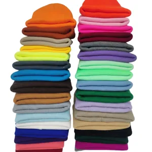 Collection of various candy-colored knit beanies stacked to show vibrant winter options.
