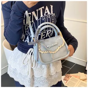 Detailed view of light blue small square handbag featuring lace trim and a cute bow knot