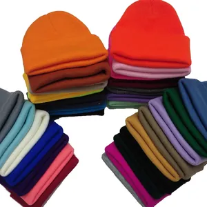 Collection of warm winter knitted beanies in multiple solid candy colors stacked neatly