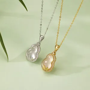 Detailed close-up of elegant S925 silver and gold gourd pendants with inlaid white stones