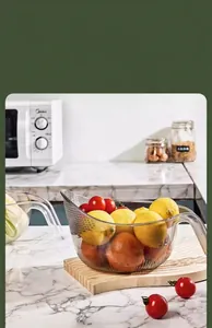 Transparent kitchen drain basket holding fresh lemons on a marble countertop scene