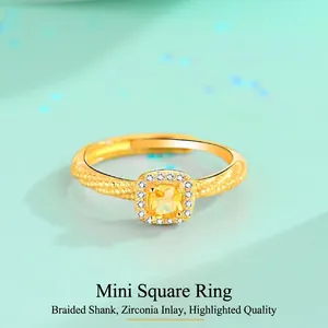 Macro view of gold-plated ring featuring square yellow zircon and braided band