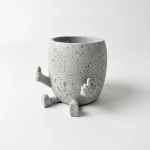 Close-up of gray speckled resin planter with middle finger gesture and smiley face.