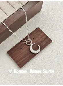 Close-up of S925 silver crescent moon necklace with sparkly finish and toggle clasp