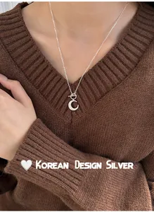 Close-up of shimmering crescent moon pendant on s925 sterling silver OT buckle necklace