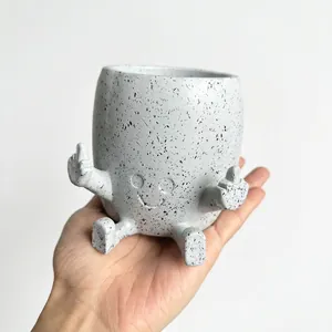 Detail shot of funny resin middle finger planter with speckled finish
