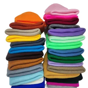 Variety of solid candy-colored knitted beanies stacked together for winter