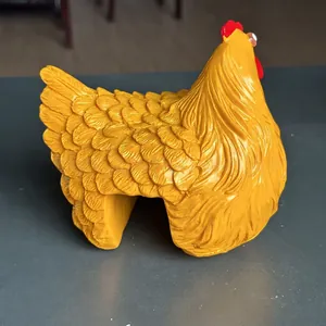 Close-up of yellow resin hen garden ornament featuring detailed feather texture and design