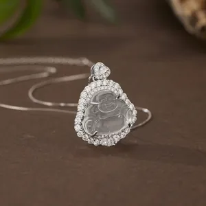 Macro detail of a laughing Buddha pendant set in silver with a delicate sterling chain.