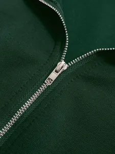 Close-up of the silver metal zipper on a dark green casual sporty long-sleeved top.
