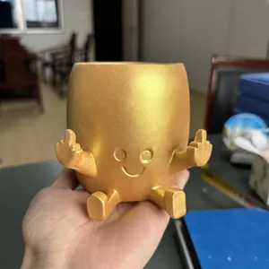 Gold resin succulent flower pot featuring a funny smiling face and middle finger gesture