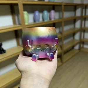 Close-up of rainbow resin flower pot featuring funny middle finger gesture design