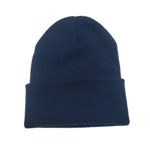 Close-up of a classic navy blue knitted beanie with ribbed texture and folded cuff.