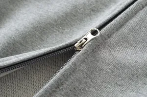 Detail macro shot of a silver metal zipper on a high-quality heather grey sweatshirt