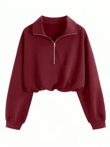 Detailed view of a burgundy half-zip cropped sweatshirt with an adjustable drawstring hemline