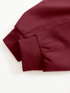 Macro view showing the wine red ribbed cuffs of a casual long-sleeve women's top jacket