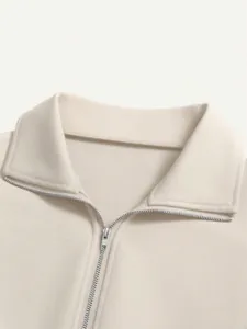 Detail view of the high-quality zipper and turn-down collar on this beige sweatshirt