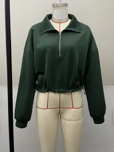 Front detailed view of a dark green half-zip cropped sweatshirt on a display mannequin.