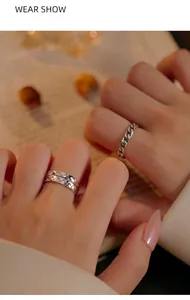 Close-up detail showing vintage S925 silver chain and textured rings on a person's hand