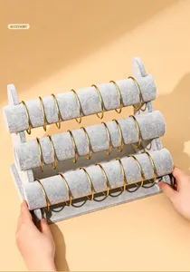 Detailed view of grey velvet 3-tier bracelet display stand holding gold bangles