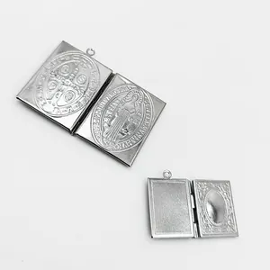 Detailed macro view of an open stainless steel book locket with religious engravings