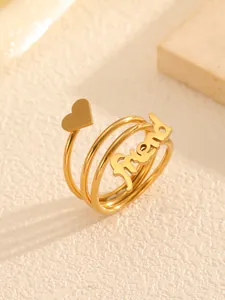 Close-up of a gold-tone spiral ring featuring a heart and 'friend' script design